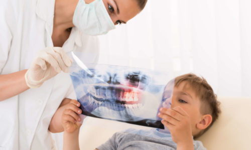 Orthodontist explains braces treatment to a child